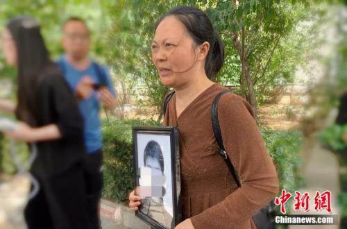 謝雕母親帶著謝雕的遺照走出法院 <a target='_blank' >中新網(wǎng)</a> 楊雨奇 攝 點(diǎn)擊進(jìn)入下一頁